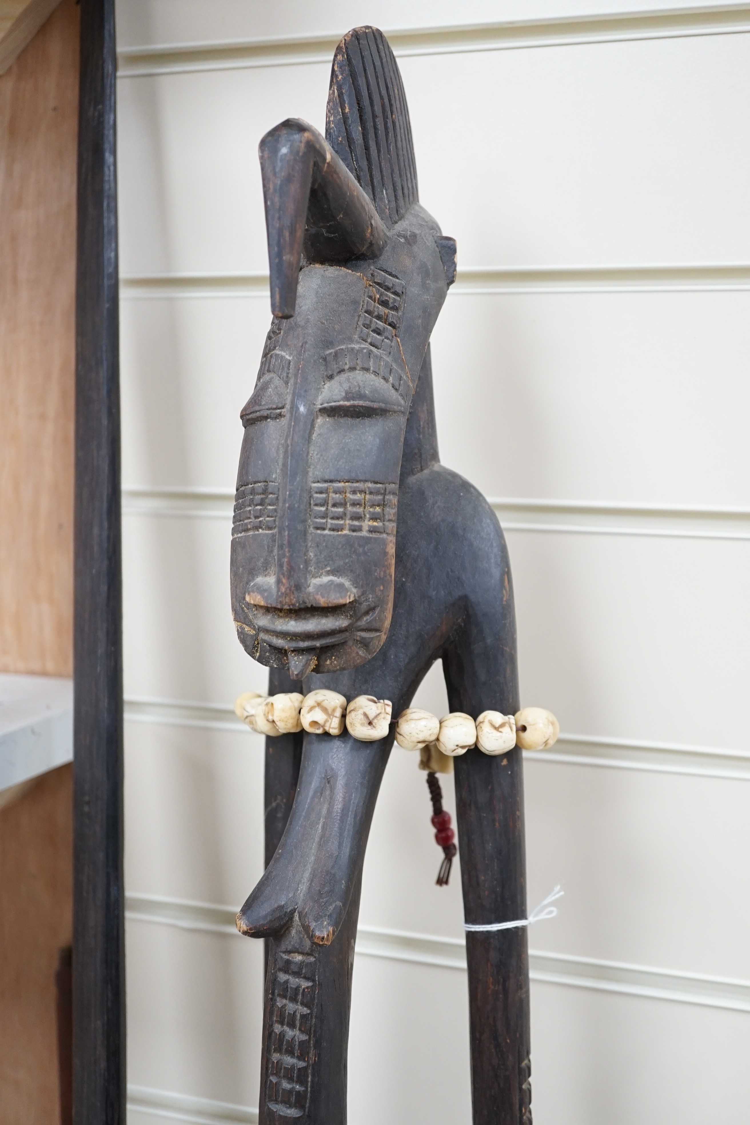 Four tribal hardwood carvings, two bows and two bronze spears longest 85cm